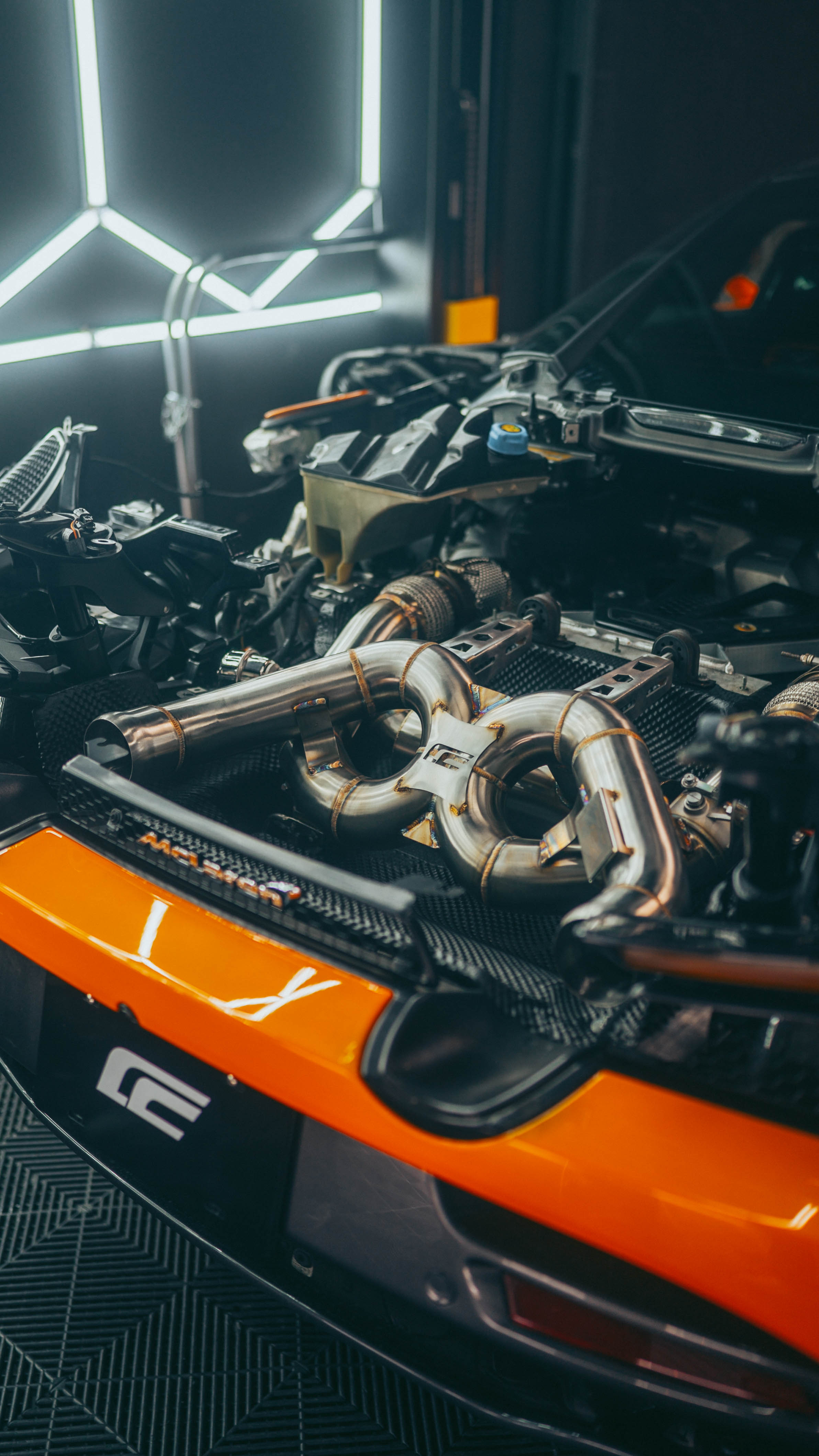 McLaren 720S exhaust X-pipe with orange 720S in background
